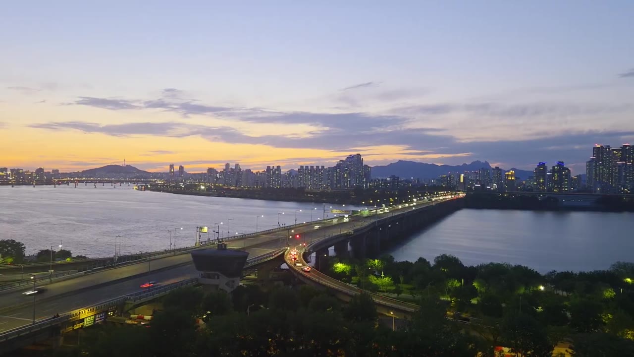 서울의 강과 도시를 담은 와이드 영상, 중앙 워드마크와 넓은 검색창이 만드는 절제된 권위.