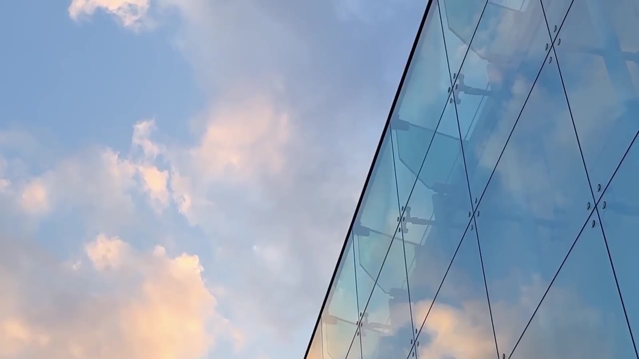 세로로 긴 건축 영상과 브론즈 선, 짙은 남색이 만나는 프리미엄 구성.